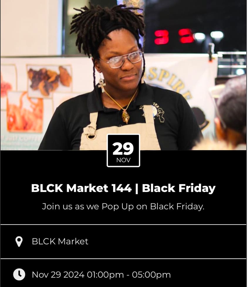 A black woman is sitting in front of an advertisement.